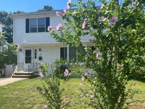 a house with pink flowers in front of it at Room in Single Family House - Suburban Neighborhood in Boston in Boston