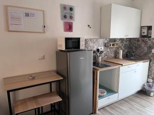 a small kitchen with a refrigerator and a table at Loft Largo Gloria in Messina