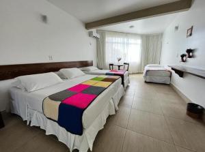 a large bedroom with two beds and a window at Hotel Fazenda Triunfo in Areia