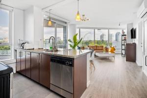 a kitchen with a counter and a living room at GardenView Modern Condo with Parking, Gym, Pool, AC in Vancouver