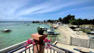 uma vista para uma praia com barcos na água em PRIVATE COLLECTION 贅沢 Jade's Beach Villa 별장 Cebu-Olango An exclusive private beach secret em Lapu Lapu City