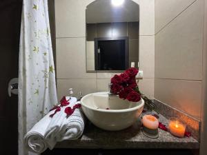 a bathroom with a sink with roses and candles at Five Stars Suites - Kennedy - Guayaquil in Guayaquil