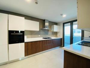 a kitchen with white cabinets and a black appliance at Appartement Ocean View - Marina Casablanca in Casablanca