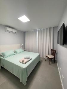 1 dormitorio con 1 cama, 1 silla y TV en Ipanema - Rainha Elizabeth - 2 Quartos, en Río de Janeiro