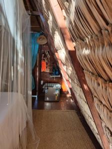 a attic room with a bed and a curtain at Ecocamping Lumiar in Amontada