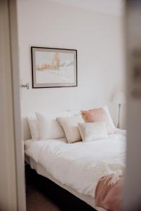 - une chambre avec un lit doté de draps et d'oreillers blancs dans l'établissement Ravenswood Farmhouse, à Rylstone