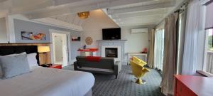 a bedroom with a bed and a chair and a fireplace at The Hotel at Cape Ann Marina in Gloucester