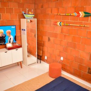 a room with a red brick wall and a mirror at Barra da Tijuca Rio de Janeiro ilha da gigoia in Rio de Janeiro