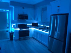 a kitchen with blue lighting in a kitchen with a refrigerator at PODLIFE in Los Angeles