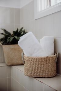 un panier de papier toilette sur un comptoir avec une plante dans l'établissement Ravenswood Farmhouse, à Rylstone