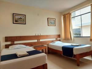 a bedroom with two beds and a window at Hotel Arizona Piura in Piura