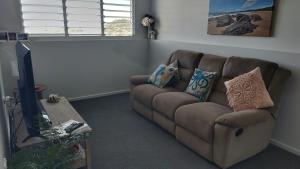 a living room with a couch and a tv at Hidden Gem Holiday Let in South Mission Beach