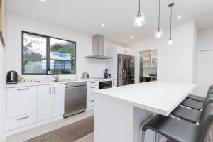 a kitchen with white cabinets and a white counter top at Pembroke Heights in Moeraki