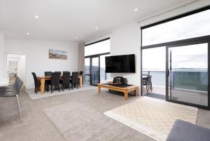a living room with a television and a table with chairs at Pembroke Heights in Moeraki
