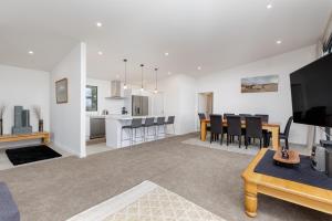 a living room with a kitchen and a dining room at Pembroke Heights in Moeraki