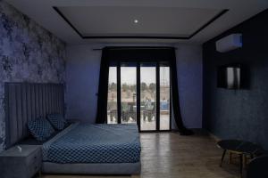um quarto com uma cama e uma grande janela em VILLA MYAD em Marrakech
