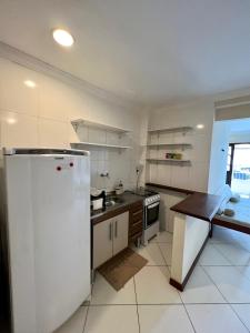 a kitchen with a white refrigerator and a table at Residencial Ribeiro in Salvador