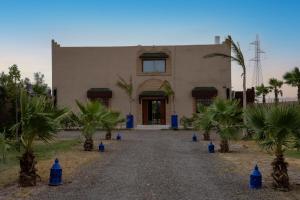 a building with palm trees in front of it at VILLA MYAD in Marrakesh