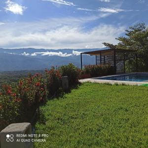 een zwembad aan de zijkant van een heuvel met bloemen bij Casa de campo con piscina, en un clima ideal y un paisaje excepcional in Santa Fe de Antioquia