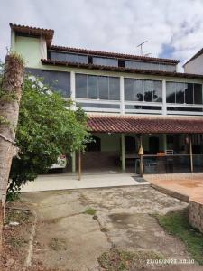 a large building with a tree in front of it at Casa agradável com piscina a 200 metros da praia in Vila Velha