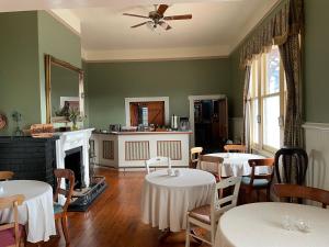 une salle à manger avec deux tables et une cheminée dans l'établissement The Exchange Hotel - Offering Heritage Style Accommodation, à Beaconsfield