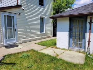 a white house with a door and a yard at Cozy downtown two bedrooms free parking in Kingston