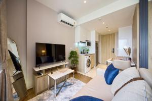 Once condo - Pattaya central location - Brand new apartments في باتايا سنترال: غرفة معيشة بها أريكة وتلفزيون