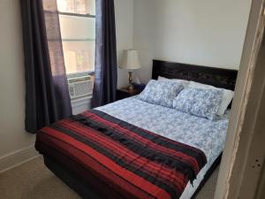 Ce lit se trouve dans une chambre dotée d'une fenêtre et d'un couvre-lit. dans l'établissement Cozy downtown two bedrooms free parking, à Kingston