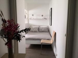 een kamer met een bed en een stoel en een vaas met bloemen bij La Charmille du Lac in Créteil