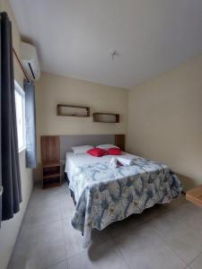 un dormitorio con una cama con un animal de peluche en Apartamento Aconchegante, en Brotas