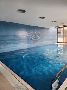 uma grande piscina com uma pintura na parede em TAKSiM SQUARE PERFECT FAMILY RESIDENCE WITH POOL em Istambul