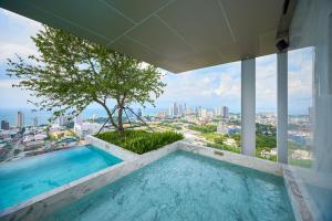 a swimming pool on top of a building with a tree at Once condo - Pattaya central location - Brand new apartments in Pattaya Central