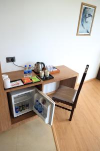 a small refrigerator in a room with a table and a chair at Hotel Sky Sierra Wayanad in Kalpetta