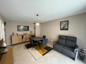 a living room with a table and chairs and a couch at Appartement Les Sables-d'Olonne, 2 pièces, 2 personnes - FR-1-197-583 in Les Sables-d'Olonne