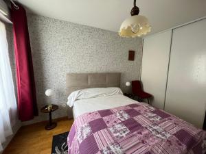 1 dormitorio con 1 cama con manta morada en Appartement Les Sables-d'Olonne, 2 pièces, 2 personnes - FR-1-197-583, en Les Sables-dʼOlonne