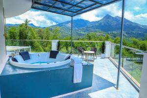 a bath tub on a balcony with a view of mountains at Hotel Sky Sierra Wayanad in Kalpetta