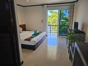 a bedroom with a bed and a large window at Cha-Cha Hotel in Ko Lanta