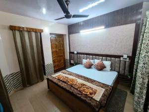 1 dormitorio con 1 cama y ventilador de techo en Aatithya Homestay Raison,Manali, en Kulu