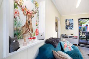 um quarto com uma cama azul e um mural de árvore em Tullys Hut em Wentworth Falls