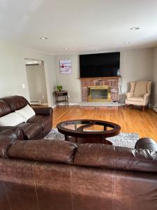 sala de estar con 2 sofás marrones y chimenea en Room in Single Family House - Suburban Neighborhood in Boston, en Boston