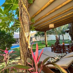 a patio with a canopy and a table and chairs at Casa Charme Conforto Arraial Dajuda Piscina privativa in Arraial d'Ajuda
