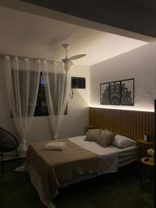 1 dormitorio con 1 cama y ventilador de techo en Casa da Lola en Angra dos Reis