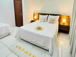 a bedroom with a large bed with a white bedspread at Casa Charme Conforto Arraial Dajuda Piscina privativa in Arraial d'Ajuda +60 photos