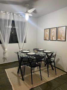 uma sala de jantar com uma mesa de vidro e cadeiras em Casa da Lola em Angra dos Reis