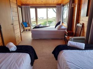 a room with two beds and a window at Edgewater Motel in Orewa