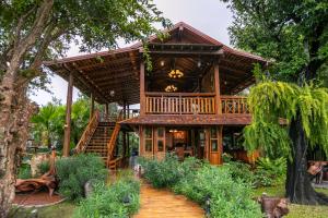 a wooden house with a wrap around porch at Saksila Resort in Nan