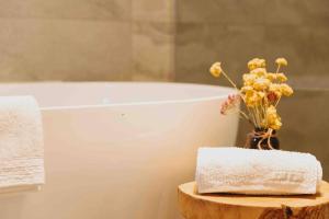a bathroom with a toilet and a vase of flowers at Whimsical Willunga Getaway in Willunga +42 photos