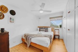 a white bedroom with a bed and a window at Whimsical Willunga Getaway in Willunga