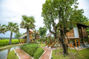 a resort with a tree house and a pond at Saksila Resort in Nan