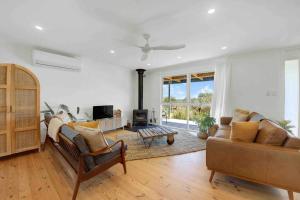 a living room with two couches and a fireplace at Whimsical Willunga Getaway in Willunga